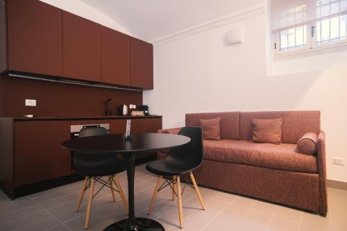 uma sala de estar com uma mesa e um sofá em Youroom Monteverde - Rooms em Roma