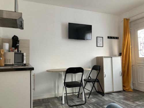 Il comprend une cuisine équipée de 2 chaises, d'une table et d'un réfrigérateur. dans l'établissement Studio indépendant, à Raismes