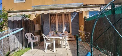 eine kleine Terrasse mit einem Tisch und Stühlen in der Unterkunft Mazet 5 pers plage parking gratuit wifi clim in La Londe-les-Maures