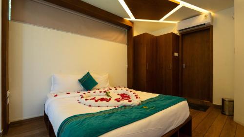 a bedroom with a large bed with red flowers on it at Escape Resorts Vayalada in Kozhikode