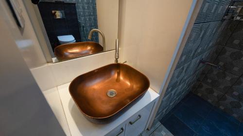 a bathroom with a copper sink and a mirror at Escape Resorts Vayalada in Kozhikode