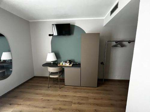 a room with a desk and a table with a chair at Hotel Oasi Wellness & Spa in Riva del Garda
