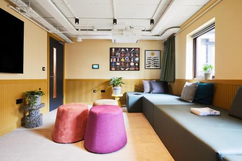 a waiting room with two couches and pink ottoman at Unite Students - The Bridge House - Fountainbridge in Edinburgh