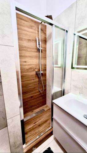 a shower with a wooden door in a bathroom at Hanza Tower De Lux Green in Szczecin