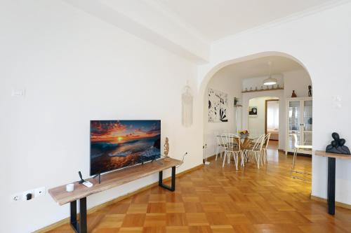 a living room with a flat screen tv on a wall at Central Kolonaki flat B - Greecing in Athens