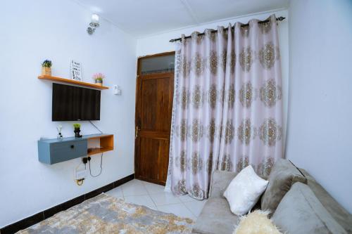 Una sala de estar con un sofá y una ventana. en BnV homes, en Dar es Salaam