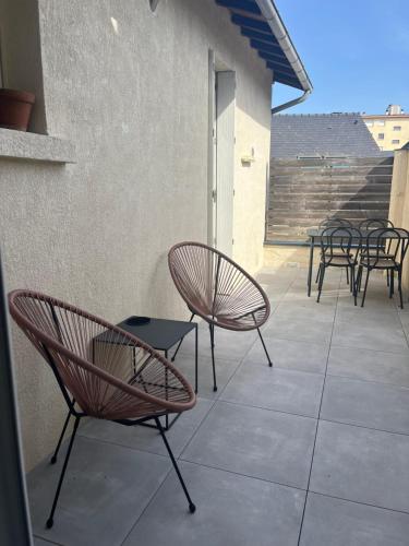 eine Gruppe von Stühlen und Tischen auf einer Terrasse in der Unterkunft Duplex de charme en centre ville avec terrasse in Brive-la-Gaillarde