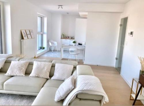 een woonkamer met een witte bank en een tafel bij Luxury apartment with stunning view - Guillemins in Brussel