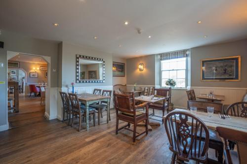 a dining room with wooden tables and chairs at The Bedingfeld Arms in Swaffham