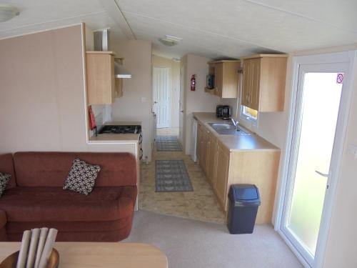 a living room with a couch and a kitchen at Seaview Ingoldmells Bromley 10 Berth 4 Bedrooms FREE WIFI in Ingoldmells