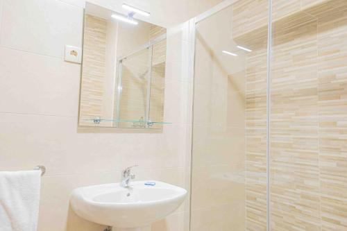 La salle de bains est pourvue d'un lavabo et d'une douche en verre. dans l'établissement Apartment Sea view 1B, à Portimão