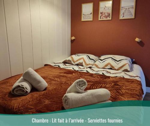 un lit avec deux serviettes dessus dans l'établissement Appartement cosy 1 chambre Saint-Malo, à Saint-Malo