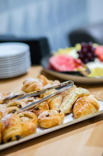a tray of pastries on a table with plates of food at Holiday Inn Milton Keynes Central by IHG in Milton Keynes