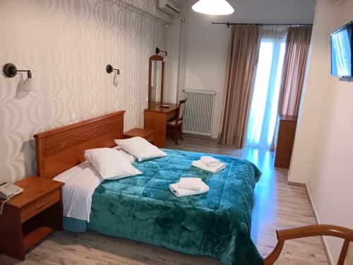 1 dormitorio con 1 cama con 2 toallas en Hotel Liberty en Mesolongion