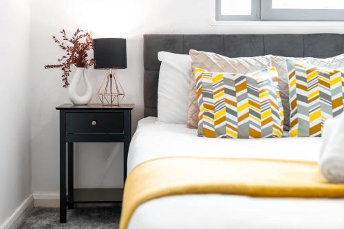 Schlafzimmer mit einem Bett und einem Beistelltisch mit einer Lampe in der Unterkunft Large City Centre Apartment - Balcony - Free Wifi & Netflix 85S in Birmingham
