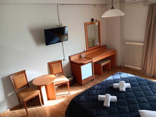 邁索隆吉的住宿－里布雷特酒店，一间卧室配有一张床、一张桌子和一面镜子