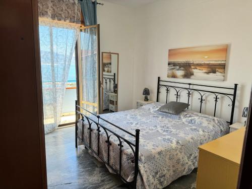a bedroom with a bed and a large window at Vista Mare in Trappeto