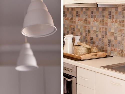 a kitchen with white cabinets and a light fixture at Little Bird Lesvos in Petra