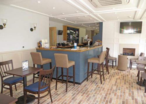 a bar in a restaurant with tables and chairs at Old Nene Golf And Country Club in Upwood