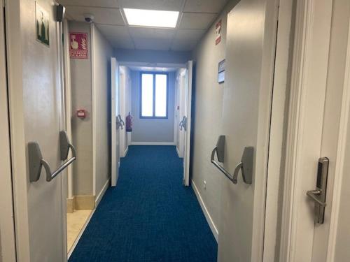 a hallway in an office building with a blue carpet at Miralcampo in Azuqueca de Henares