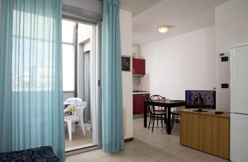 Residence Villa Azzurra في ريميني: مطبخ وغرفة طعام مع ثلاجة وطاولة