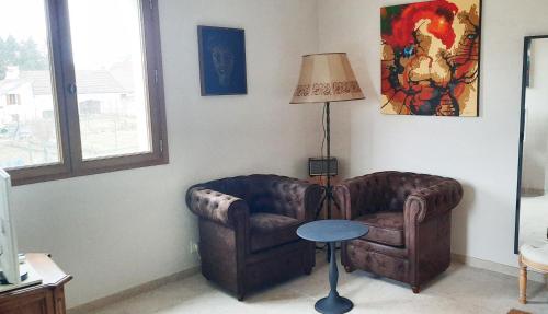 un salon avec un canapé et une lampe dans l'établissement Petite maison d'art et d'hôtes, à Leuglay