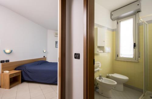 a bathroom with a bed and a toilet and a sink at Residence Villa Azzurra in Rimini