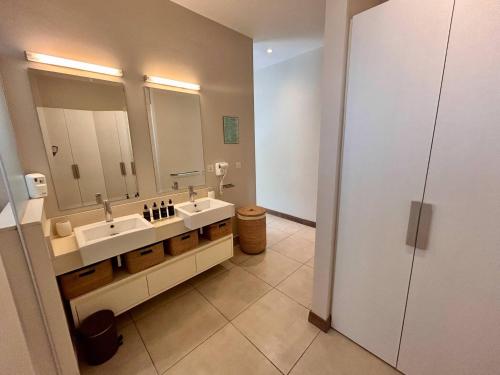 a bathroom with two sinks and a large mirror at Unique Beachfront Appartment in Trou aux Biches