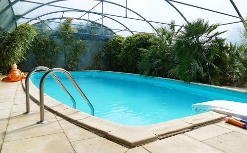 - une piscine dans une maison en verre avec toboggan dans l'établissement Petite maison d'art et d'hôtes, à Leuglay