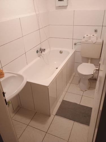 bagno bianco con vasca e servizi igienici di Monteurzimmer Pavan H1 - KEINE FERIENWOHNUNG a Gevelsberg