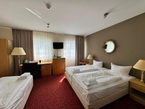 a hotel room with two beds and a desk at Hotel Bonverde (Wannsee-Hof) in Berlin