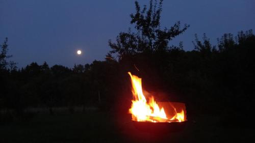 a fire pit with the moon in the background at Prázdninový dům - PACL Červená Řečice in Červená Řečice