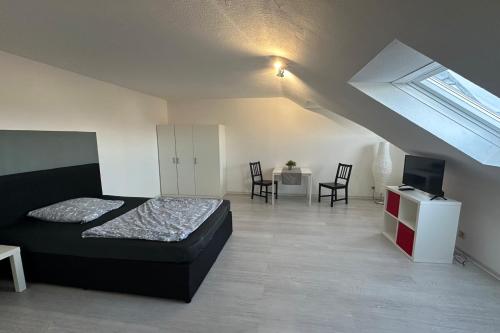 - une chambre avec un lit, une table et des chaises dans l'établissement Schönes Apartment im Dachgeschoss in Mannheim Nahe Rheinauer See, à Mannheim