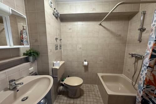 La salle de bains est pourvue d'un lavabo, de toilettes et d'une baignoire. dans l'établissement Schönes Apartment im Dachgeschoss in Mannheim Nahe Rheinauer See, à Mannheim