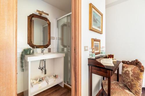 a bathroom with a sink and a desk next to a mirror at Guest House Maison 6 in Lido di Ostia