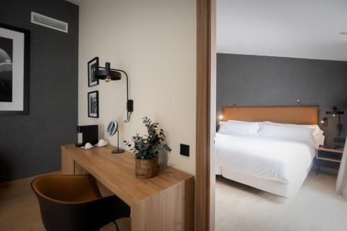 a hotel room with a bed and a desk with a chair at Hotel & Spa Convento San Francisco in Soria