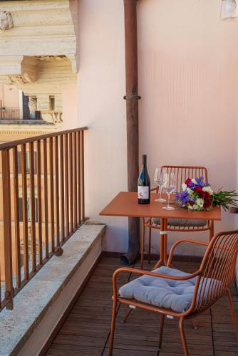 a table and chairs on a balcony with a bottle of wine at Salotto Monti in Rome