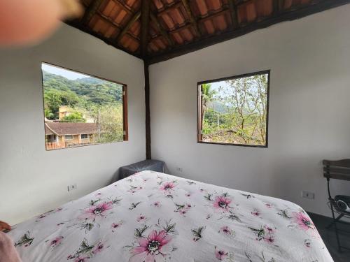 a bedroom with a bed and two windows at Casa da JUJU - Praia da Lagoinha - Ubatuba in Ubatuba