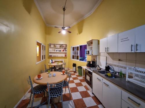 eine Küche mit einem Tisch und Stühlen im Zimmer in der Unterkunft Hostel Estoril in Buenos Aires