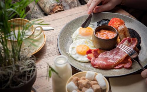 a plate of breakfast food on a wooden table at Beaulieu Hotel in Lyndhurst