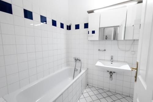 Baño blanco con bañera y lavamanos en Getreide T8 en Viena