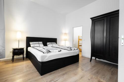 1 dormitorio con 1 cama grande y armario negro en Getreide T8 en Viena