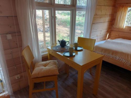 a bedroom with a table and a bed and a table and chairs at Gemütliches Tiny House Uggla im Wald am See in Torestorp