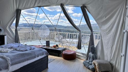 a bedroom with a bed and a large window at Dorna Iglu Luxury Glamping Resort in Dorna Cîndrenilor