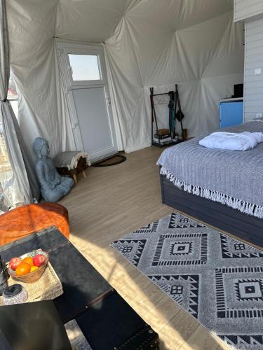 a bedroom with a bed and a table with a bowl of fruit at Dorna Iglu Luxury Glamping Resort in Dorna Cîndrenilor