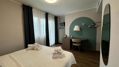a hotel room with a bed with towels on it at Hotel Oasi Wellness & Spa in Riva del Garda