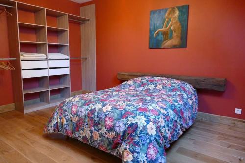 a bedroom with a bed with a colorful bedspread at La maison d'art et d'hôtes in Leuglay