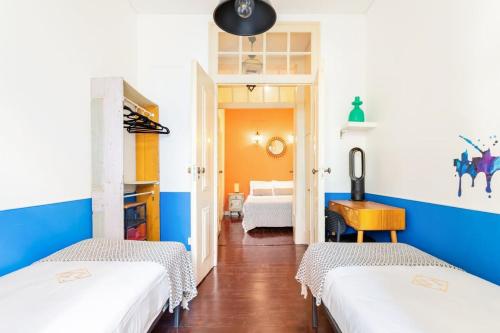 リスボンにあるLD Apartments Alfamaの青と白の壁の客室で、ベッド2台が備わります。