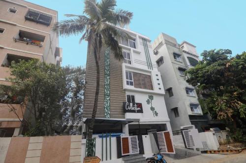 a palm tree in front of a building at Super Collection O RCC Pristine in Hyderabad