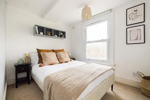 a white bedroom with a bed and a window at The Brockwell Park Place - Bright 2BDR Flat in London